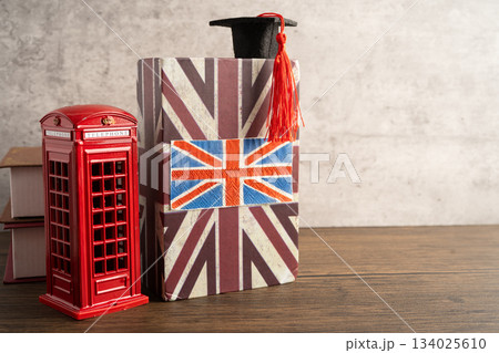 UK flag with graduate hat on english language book. UK flag with graduate hat on english language book. 134025610