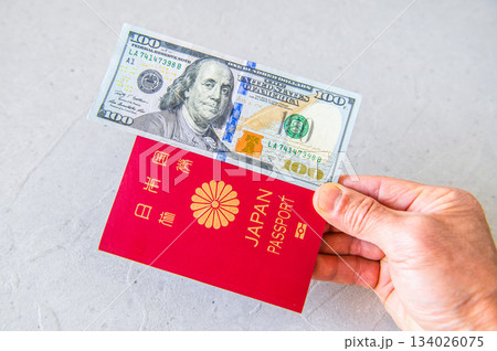 米100ドル札・日本パスポートを右手で右側から差し出す 134026075