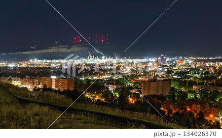 A night view of Billings, Montana. The oil refinery is brightly lit below the Rimrocks cliffs, which are topped with tall red antenna towers 134026370