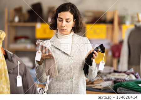 Latin American woman search and choose warm glove in shop 134026414