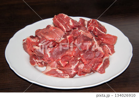 Piece of raw beef on a wooden cutting board. Piece of raw beef on a wooden cutting board. 134026910