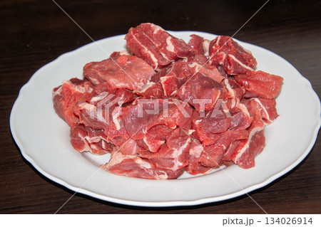 Piece of raw beef on a wooden cutting board. Piece of raw beef on a wooden cutting board. 134026914