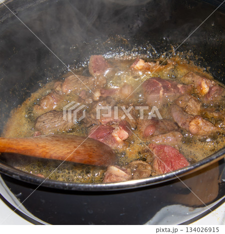 Preparing a hash with onions and stew beef. 134026915