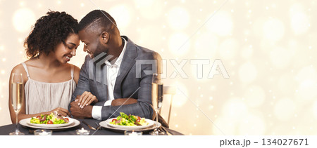 African couple in love bonding while having dinner at restaurant, love and relationships concept African couple in love bonding while having dinner at restaurant, love and relationships concept 134027671