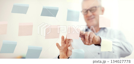 Presentation Concept. Successful middle-aged business man putting his ideas on sticky notes in conference room 134027778