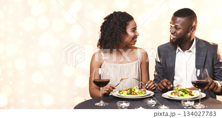 First date. African young man and woman talking while having dinner in restaurant 134027783