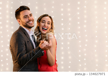 Party For Two. Joyful Young Couple Dancing, Holding Hands And Sincerely Laughing While Posing Over Beige Background With Bokeh, Panorama 134027971