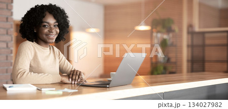 Positive black woman sitting at cafe. working online, using laptop, copy space Positive black woman sitting at cafe. working online, using laptop, copy space 134027982