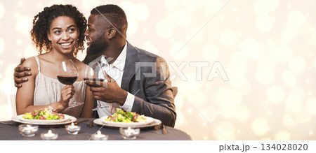 First date. Black man in love courting pretty lady, having dinner at restaurant 134028020