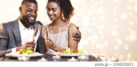 Young black couple toasting with champagne while having dinner at restaurant, close up 134028021