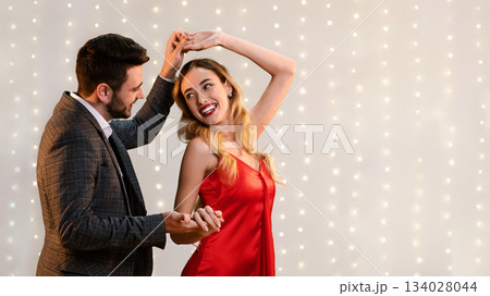 Cheerful Romantic Couple Dancing Together On Date In Restaurant, Holding Hands And Enjoying Valentine's Day Celebration, Empty Space 134028044