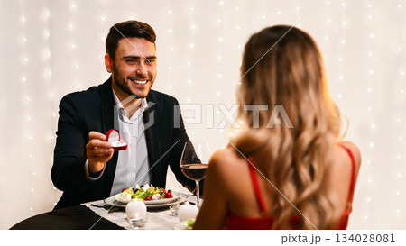 Romantic Proposal. Loving Man Asking His Girlfriend To Marry Him On Date In Restaurant, Selective Focus, Free Space 134028081