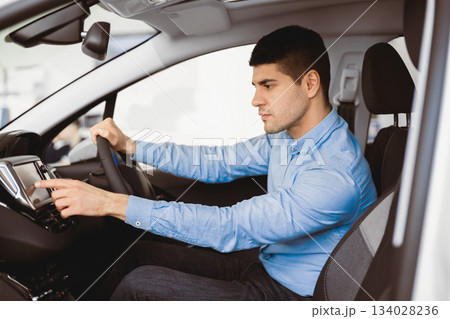 Transport, Destination, Modern Technology Concept. Man searching for route using navigation system on car dashboard screen 134028236