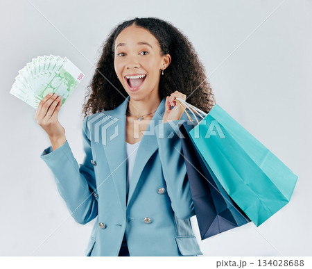 Happy woman, portrait and shopping bags with money winning sale or discount against white studio background. Excited and surprised female shopper smiling with cash, gift or profit in retail happiness Happy woman, portrait and shopping bags with money winning sale or discount against white studio background. Excited and surprised female shopper smiling with cash, gift or profit in retail happiness 134028688