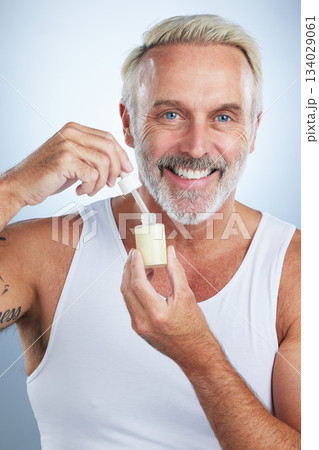 Beauty, skincare and serum with portrait of man in studio for anti aging, cosmetics and spa treatment. Product, facial and vitamin c with senior model on gray background for wrinkles, retinol and oil Beauty, skincare and serum with portrait of man in studio for anti aging, cosmetics and spa treatment. Product, facial and vitamin c with senior model on gray background for wrinkles, retinol and oil 134029061