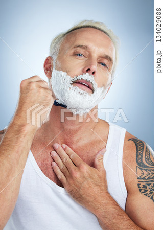 Senior man, razor and shaving beard with cream for grooming, skincare or hair removal against a studio background. Portrait of mature male with shaver, creme or foam for hygiene or facial treatment 134029088