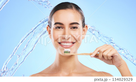 Portrait, water splash or happy girl brushing teeth with product for healthy oral or dental hygiene in studio. Face, smile beauty or woman model cleaning mouth with a natural bamboo wooden toothbrush 134029329