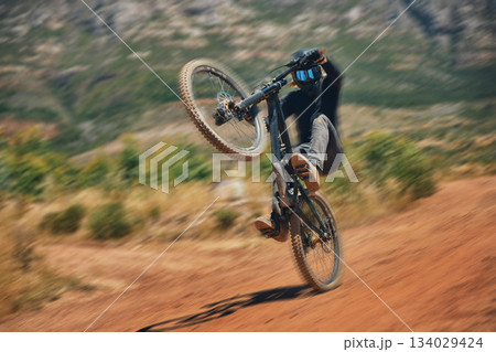 Cycling, training and person on a bicycle in the countryside for extreme sport, adrenaline and fun. Speed, action and cyclist on a dirt road for stunt, trick or fitness, freedom and balance in nature Cycling, training and person on a bicycle in the countryside for extreme sport, adrenaline and fun. Speed, action and cyclist on a dirt road for stunt, trick or fitness, freedom and balance in nature 134029424