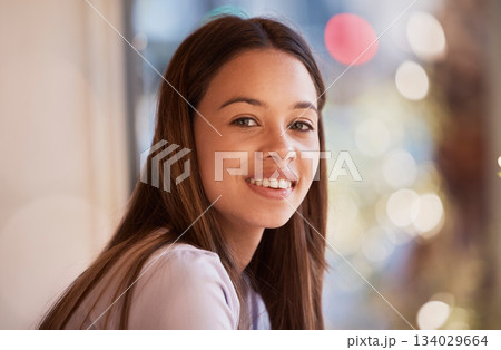 Portrait, happy and a woman in a coffee shop, sitting by the window to relax alone over the weekend. Face, smile and cafe with an attractive young female customer waiting for service in a restaurant 134029664
