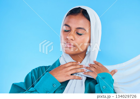 Calm woman, muslim and beauty of hijab in studio, blue background or color backdrop. Young female model, islamic culture or scarf with eyes closed, peace or religion of arabic fashion for eid mubarak 134029726
