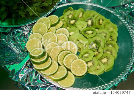 Fresh citrus and tropical slices, Vibrant arrangement of fruits on reflective surface, Exquisitely layered citrus and tropical fruits showcased for festive presentation Fresh citrus and tropical slices, Vibrant arrangement of fruits on reflective surface, Exquisitely layered citrus and tropical fruits showcased for festive presentation 134029747