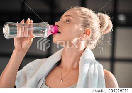 Fitness, athlete and woman drinking water in gym after workout, training or exercise. Sports, nutrition and thirsty athletic female drink liquid aqua from bottle for hydration, health and wellness Fitness, athlete and woman drinking water in gym after workout, training or exercise. Sports, nutrition and thirsty athletic female drink liquid aqua from bottle for hydration, health and wellness 134029759