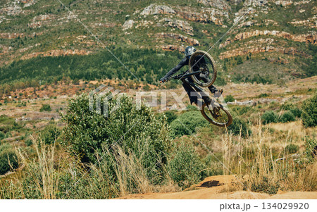 Jump, extreme sports and mountain bike with man in nature for cycling, fitness and adventure. Adrenaline junkie, performance and stunt with athlete riding in outdoors for action, risk and training Jump, extreme sports and mountain bike with man in nature for cycling, fitness and adventure. Adrenaline junkie, performance and stunt with athlete riding in outdoors for action, risk and training 134029920