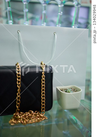 Refined evening handbag presented on sleek glass platform with gentle illumination, Sophisticated purses highlighted with subtle shadows and polished high end ambiance Refined evening handbag presented on sleek glass platform with gentle illumination, Sophisticated purses highlighted with subtle shadows and polished high end ambiance 134029948