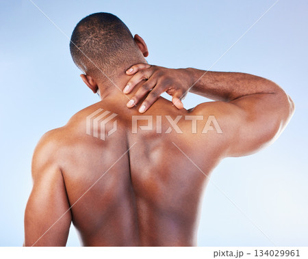 Black man, neck pain and injury with fitness and health, medical problem and aching body with back view. Emergency, muscle tension and male athlete with joint ache from workout on blue background Black man, neck pain and injury with fitness and health, medical problem and aching body with back view. Emergency, muscle tension and male athlete with joint ache from workout on blue background 134029961
