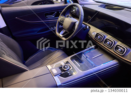 Closeup of a modern car steering wheel with control buttons for technology and convenience 134030011