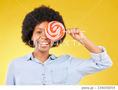 Cover, candy and lollipop with black woman in studio for colorful, cheerful and positive. Young, happiness and dessert with female isolated on yellow background for treats, food and confectionary 134030054