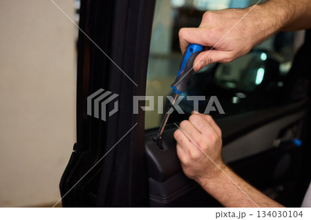 Mechanic fixing vehicle door parts, Closeup of technician repairing car interior components, Professional worker servicing vehicle door with detailed focus and tools Mechanic fixing vehicle door parts, Closeup of technician repairing car interior components, Professional worker servicing vehicle door with detailed focus and tools 134030104