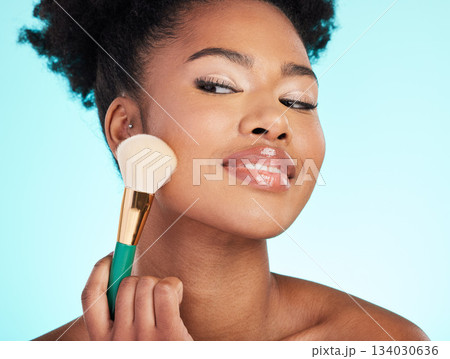 Makeup, brush and face of black woman for beauty, cosmetics and facial treatment on blue background. Salon, cosmetology and happy girl with brushes for foundation, skincare and application in studio 134030636