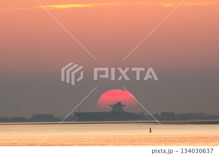 Big containership with cargo sailing through the sunset in the dusk on the Western Scheldt. 134030637