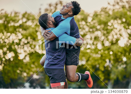 Rugby men, hug and celebration at game for winning, teamwork and success on field for sports. Team building, jumping and support for sport friends, goals and winner to celebrate achievement together Rugby men, hug and celebration at game for winning, teamwork and success on field for sports. Team building, jumping and support for sport friends, goals and winner to celebrate achievement together 134030870