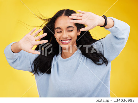 Happy, wind and face of woman with hands on yellow background with smile, happiness and freedom. Hair blowing, mockup space and isolated girl with open palms for beauty, relaxing and calm in studio Happy, wind and face of woman with hands on yellow background with smile, happiness and freedom. Hair blowing, mockup space and isolated girl with open palms for beauty, relaxing and calm in studio 134030988