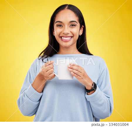 Smiling portrait, coffee mug and happy woman in a studio with a smile from espresso. Isolated, yellow background and drink of a young female with happiness and joy ready to start the day with tea 134031004