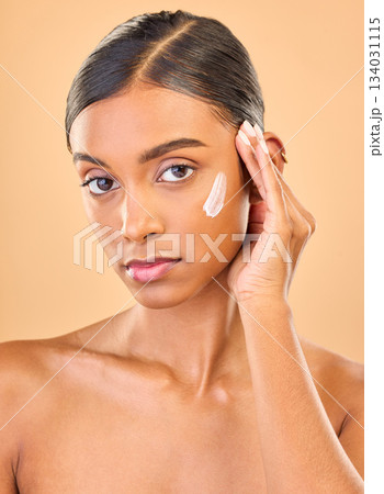Face portrait, skincare and woman with cream in studio isolated on brown background. Dermatology, serious cosmetics and confident Indian female model with lotion, creme or moisturizer for skin health Face portrait, skincare and woman with cream in studio isolated on brown background. Dermatology, serious cosmetics and confident Indian female model with lotion, creme or moisturizer for skin health 134031115