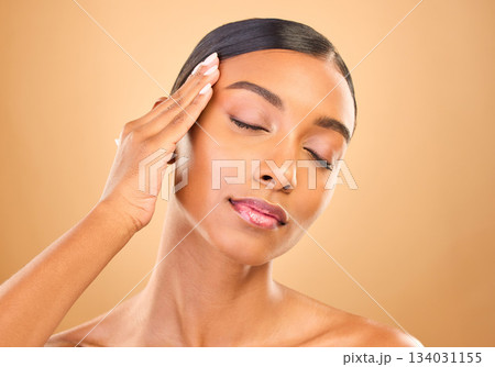 Beauty, face and skin care of a woman in studio for glow cosmetics, dermatology or makeup. Aesthetic female model for self love, natural glow and spa facial shine results on brown background Beauty, face and skin care of a woman in studio for glow cosmetics, dermatology or makeup. Aesthetic female model for self love, natural glow and spa facial shine results on brown background 134031155