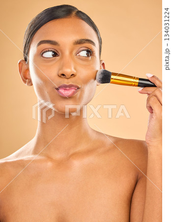 Indian woman, beauty and brush for makeup with cosmetic tools, skin glow and kiss face on studio background. Happy female, thinking and cosmetology, apply foundation or powder with self care Indian woman, beauty and brush for makeup with cosmetic tools, skin glow and kiss face on studio background. Happy female, thinking and cosmetology, apply foundation or powder with self care 134031224