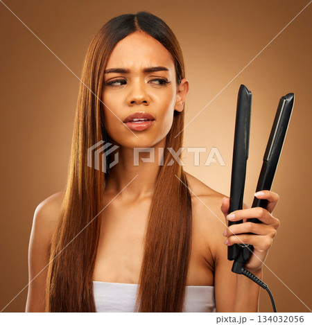 Hair, flat iron and confused woman in studio for beauty, wellness and keratin treatment on brown background. Hairdresser mockup, salon and girl with doubt for heat, haircare texture and cosmetics Hair, flat iron and confused woman in studio for beauty, wellness and keratin treatment on brown background. Hairdresser mockup, salon and girl with doubt for heat, haircare texture and cosmetics 134032056