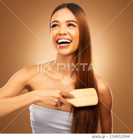 Hair brush, beauty and a happy woman in studio for growth and color shine or texture. Aesthetic female thinking, brushing and laugh for natural haircare, and hairdresser or salon on brown background 134032094