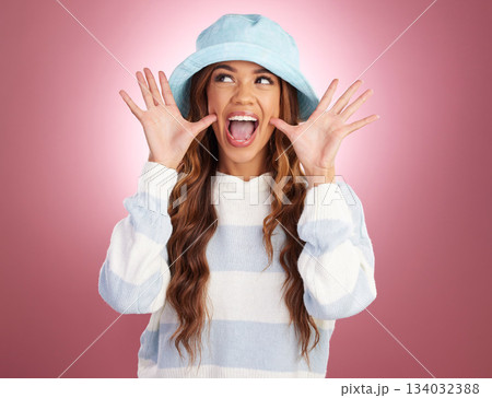 Excited, comic hands and face of woman on studio background for funny, humour and emoji reaction. Beauty, fashion and happy girl model with facial expression in trendy style, cosmetics and casual hat 134032388