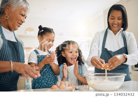 Grandmother, mom or excited children baking in kitchen as a happy family with young girl learning a recipe. Cracking eggs, clapping or grandma smiling or teaching kids to bake a cake for development 134032432