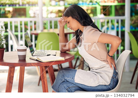 Woman with back pain, laptop in cafe and stress burnout with anxiety and overwhelmed at table. Mental health, sustainable business owner and computer with worry, injury and debt in outdoor restaurant 134032794