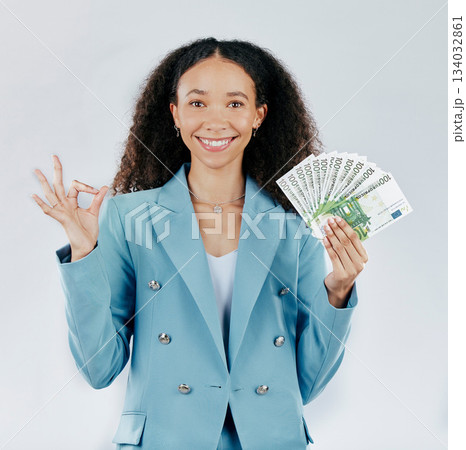 Portrait, happy and cash with a business woman in studio on a gray background making a perfect hand gesture. Face, finance and money with a female employee holding euro bills for investment 134032861