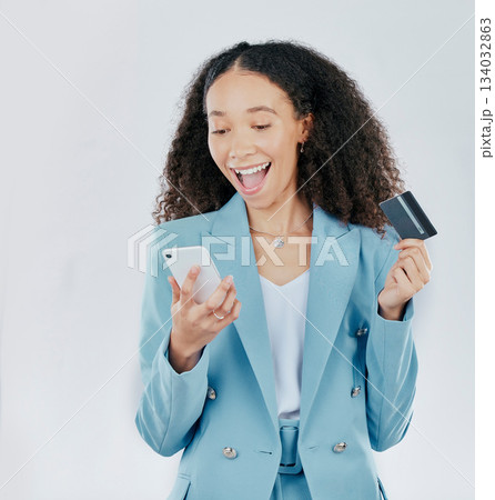 Phone, credit card and online shopping with a woman customer in studio on a gray background feeling excited. Ecommerce, sale and payment with a happy female shopper enjoying retail spending Phone, credit card and online shopping with a woman customer in studio on a gray background feeling excited. Ecommerce, sale and payment with a happy female shopper enjoying retail spending 134032863