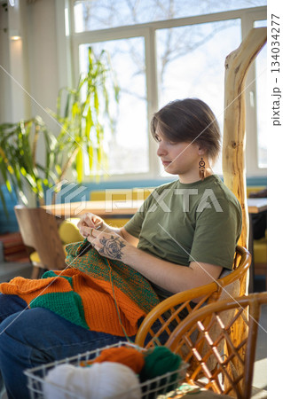 Hipster feminine male crochet handmade knitting hobby with colored yarn and hook at wooden interior Hipster feminine male crochet handmade knitting hobby with colored yarn and hook at wooden interior 134034277