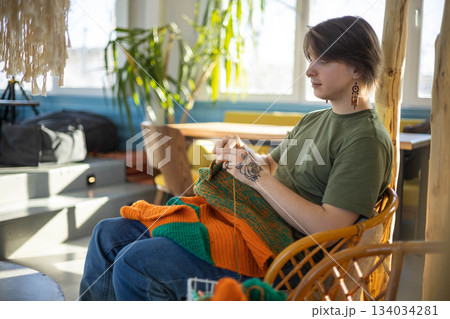 Hipster feminine male crochet handmade knitting hobby with colored yarn and hook at wooden interior Hipster feminine male crochet handmade knitting hobby with colored yarn and hook at wooden interior 134034281