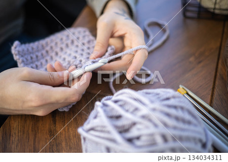Man hands crochets handmade crocheting supplies assorted wool yarn hook knitting top view closeup 134034311